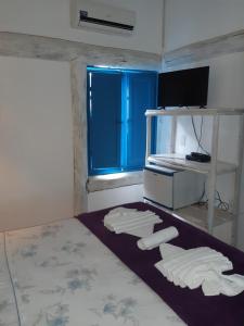 伊塔乌纳斯卡萨大普拉亚伊托纳斯旅馆的一间房间,地板上配有3条白色毛巾,并设有一个窗户