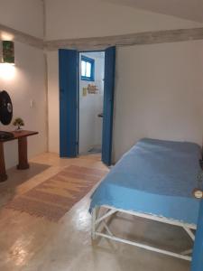 伊塔乌纳斯卡萨大普拉亚伊托纳斯旅馆的一间卧室设有蓝色的床和一扇门