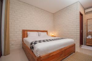 珀尼达岛The Lokal Penida by Nagisa Bali的卧室设有一张砖墙内的大床
