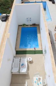 ŻejtunIl-Qastna Holiday House的享有带2把草坪椅的游泳池的顶部景致