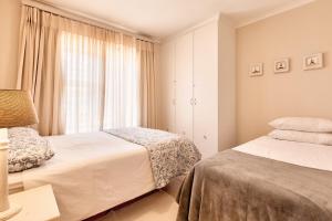 赫罗德斯湾Perlemoen Retreat的一间卧室设有两张床和窗户。