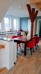 锡克Villa Appartements Syke的厨房配有木桌和红色椅子