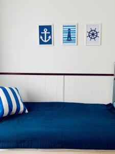 查普伊Villa Baltic Chałupy Apartament 4的卧室配有一张蓝色的床,墙上挂有图片