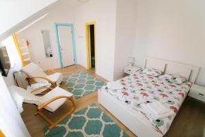 特尔古穆列什Capra Vecinului的一间卧室配有床、两把椅子和地毯