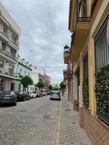 卡马斯Duplex, terraza, 10 min coche centro Sevilla的一条街道,汽车停在大楼的一侧