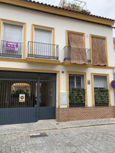 卡马斯Duplex, terraza, 10 min coche centro Sevilla的一座带黑色车库门和窗户的房子