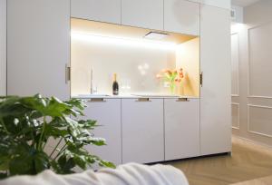 里乔内RICCIONE SUITE DESIGN的厨房配有白色橱柜和花瓶