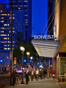 费城Sonesta Philadelphia Rittenhouse Square的一群人晚上沿着城市街道走
