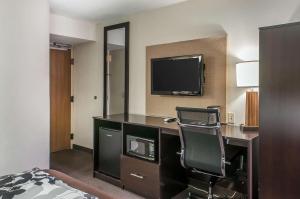 阿尔伯克基Sleep Inn Airport的酒店客房配有一张桌子、一把椅子和一台电视