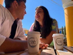 Tlatlauquitepec圣达菲酒店的坐在桌子上拿着咖啡杯的男人和女人