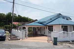 关丹Beit Azzahra Private Pool Villa at Pantai Batu Hitam的蓝色屋顶和白色围栏的房子