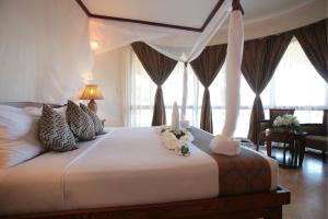 普瓦尼梅查恩加尼海洋天堂Spa度假酒店的一间卧室配有一张带蜡烛的大床