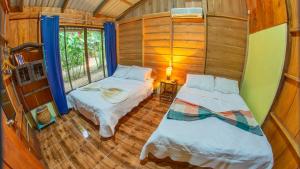 福尔图纳Cabañas del Lago的小房间设有两张床和窗户