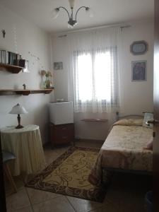 SoletoLa dimora degli angeli的一间卧室配有一张床、一张桌子和一个窗户。