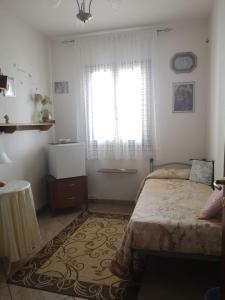 SoletoLa dimora degli angeli的一间卧室设有床、窗户和地毯。