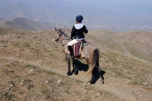 SayyodSayyod Yurt Camp的骑着马在山坡上的人