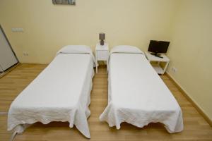 巴塞罗那巴塞罗那城市公寓的医院房间设有两张床铺,配有白色床单