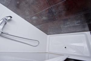 巴塞罗那巴塞罗那城市公寓的浴室设有带淋浴头的白色浴缸。