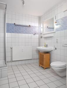 蒂门多夫Appartements Am Reiterhof Meerzeit的白色瓷砖浴室设有卫生间和水槽