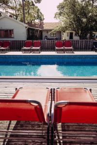 托弗塔Tofta Bed & Breakfast的一个带椅子和红色长凳的游泳池