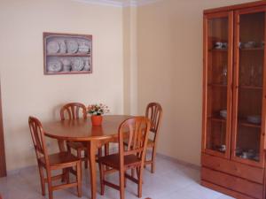 桑亨霍Apartamento Lima的一间带木桌和椅子的用餐室