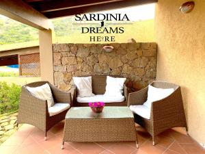 帕拉迪索海岸Villa Flavia con piscina的庭院设有藤椅和一张带标志的桌子