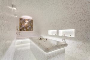 索契Wellness СПА-Отель Грейс Горизонт的白色的浴室设有浴缸和墙上的绘画作品