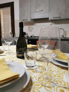 法维尼亚纳MG CASA VACANZE FAVIGNANA的一张桌子,配有酒杯和一瓶葡萄酒