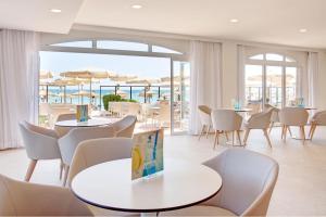 坎皮卡福特Grupotel Dunamar的一间带桌椅的海景餐厅