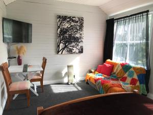 LumsdenStump Cottage的一间卧室配有一张床、一张书桌和一个窗户。