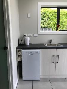 LumsdenStump Cottage的白色的厨房配有水槽和洗碗机