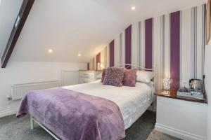 滕比蔻驰旅馆的一间卧室配有一张带紫色毯子的床
