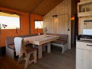 厄伊特海斯特Erfgoedpark De Hoop Glamping的一间带木桌和长凳的用餐室