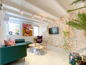 干尼亚Izmir House的客厅配有沙发和石墙电视。
