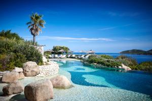 博尼法乔尤卡普班库酒店的游泳池,有岩石,棕榈树和水