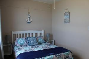 阿曼济姆托蒂Afsaal Holiday Flats的一间卧室配有一张带蓝色枕头的床