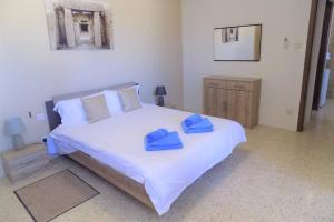 圣保罗湾城Sunshine Holiday Apartment 5 with Spectacular Seaviews的一间卧室配有一张大床,上面有蓝色的毛巾