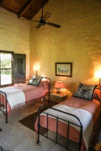 科洛尼亚卡洛斯佩莱格里尼Aguapé Lodge的一间卧室配有两张床和吊扇