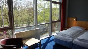 布伦瑞克Plaza Inn Braunschweig City Nord的客房设有一张床、一张书桌和窗户。