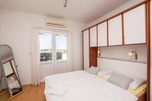 沃迪切Apartments and Rooms Mare的卧室设有一张白色大床和一扇窗户。