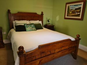 BallymahonSkellys的卧室配有一张带白色床单和枕头的大床。