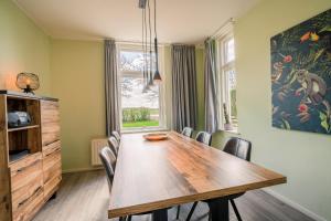 德瓦尔Nieuwlanderweg 55的一间带木桌和椅子的用餐室