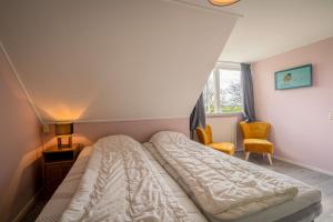 德瓦尔Nieuwlanderweg 55的一间卧室配有一张床和两把椅子