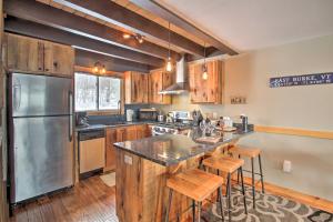 East BurkeSki-InandOut Burke Mtn Condo with Amenity Access!的厨房配有木制橱柜和不锈钢冰箱。