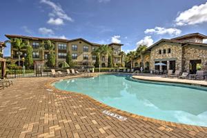 达文波特Davenport Condo with Pool Access - 11 Mi to Disney!的一座带椅子的度假村的游泳池和一座建筑