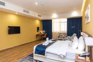 迪拜Le Wana Hotel的一间酒店客房,配有一张床和一台电视