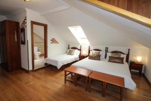 坎加斯-德奥尼斯厄尔埃斯皮诺乡村酒店的一间卧室配有两张床、一张桌子和一面镜子