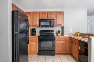 拉斯维加斯Club Wyndham Grand Desert的厨房配有黑色冰箱和木制橱柜。