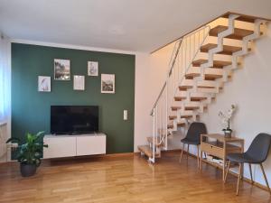 福森Ferienwohnung FüssenPur的客厅设有楼梯和平面电视。
