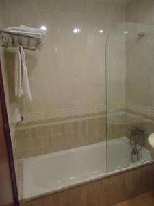阿尔卡拉兹卡萨米克尔酒店-餐厅的浴室内设有带玻璃淋浴间的浴缸